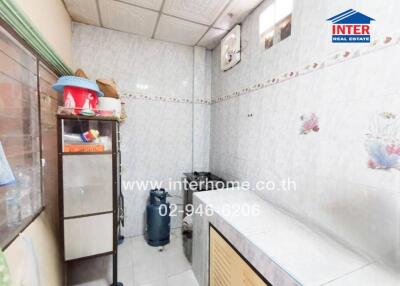 Small kitchen with tiled walls and cooking area