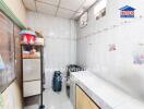 Small kitchen with tiled walls and cooking area