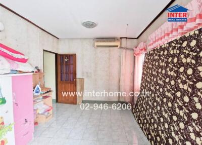 Bedroom with light-colored tile flooring, air conditioning, and patterned drapes