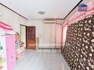 Bedroom with light-colored tile flooring, air conditioning, and patterned drapes