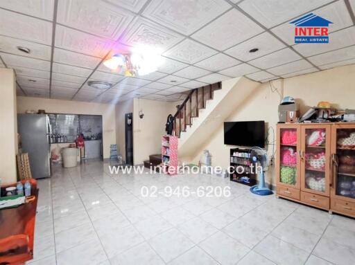 Spacious living room with modern furnishings and staircase