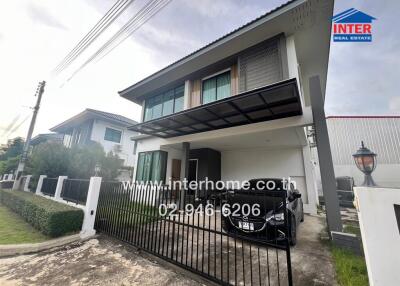 Modern two-story house with secure gate and driveway