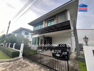 Modern two-story house with secure gate and driveway