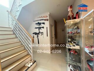 Staircase hallway with display case and weapon decorations.