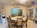 well-lit dining area with a table set for six, air conditioning, and display cabinets