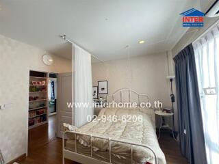 Cozy bedroom with a bed, curtain divider, and bookshelves