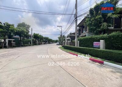 Street view of residential area with houses and greenery on a cloudy day