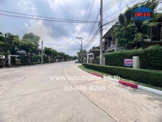 Street view of residential area with houses and greenery on a cloudy day