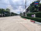 Street view of residential area with houses and greenery on a cloudy day