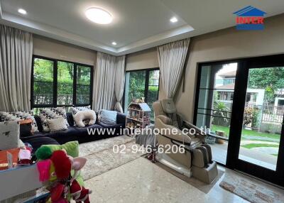 Living room with large windows, sofa, and children