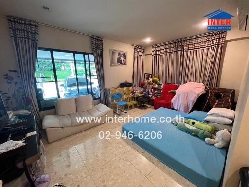 Living room with assorted furniture items and personal belongings visible.