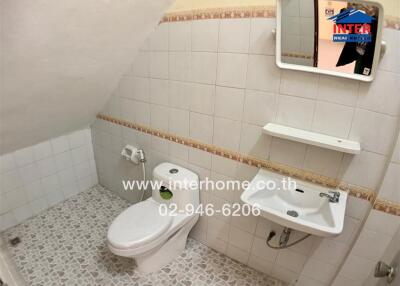 Bathroom with toilet, sink, and mirror