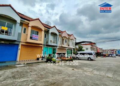 Front view of a row of townhouses with various storefronts on the ground floor.