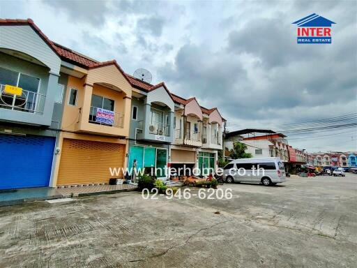 Front view of a row of townhouses with various storefronts on the ground floor.