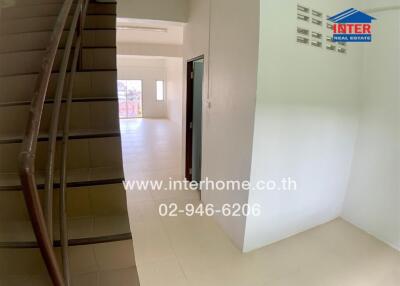 Staircase leading to an open living area with natural light