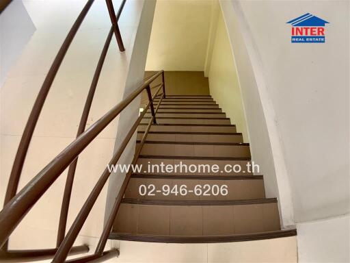 Staircase with brown railing and tiled steps