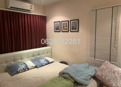 Bedroom with bed, air conditioner, and framed pictures