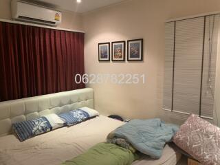 Bedroom with bed, air conditioner, and framed pictures