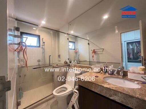 Modern bathroom with shower area, toilet, and sink counter