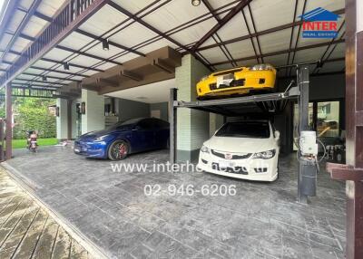 Covered garage with car lift and three parked cars