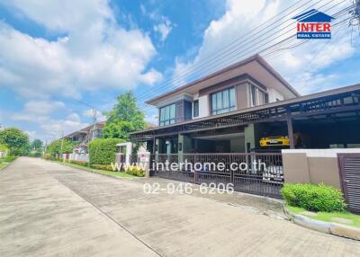 Front view of a modern two-story house with garage and surrounding greenery