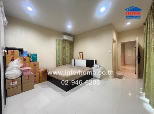 Spacious bedroom with bed, air conditioner, and storage boxes