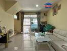 Living room with sofa, coffee table, TV, and large windows