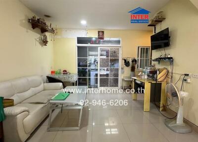 Spacious living room with white sofa and wall-mounted TV