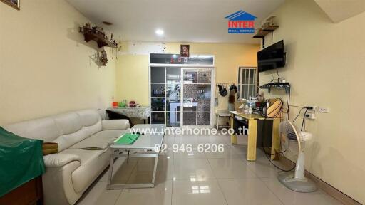 Spacious living room with white sofa and wall-mounted TV