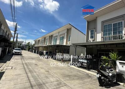 Street view of residential buildings with garages and parked vehicles