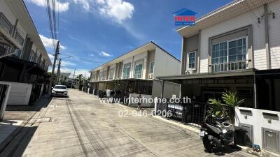 Street view of residential buildings with garages and parked vehicles