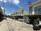 Street view of residential buildings with garages and parked vehicles