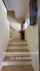 Staircase with wooden steps and a small window