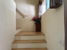 Staircase with wooden steps and a small window