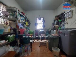 Kitchen with storage shelves, appliances, and utensils