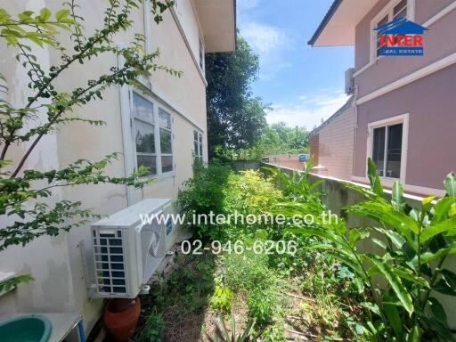 Side view of the property showing garden area with air conditioner unit