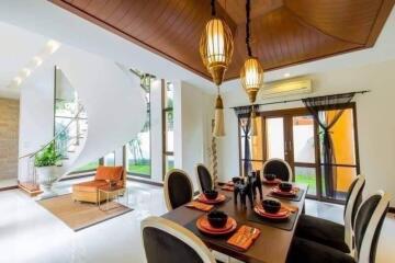 Modern dining area with stylish lighting and a view of a spiral staircase