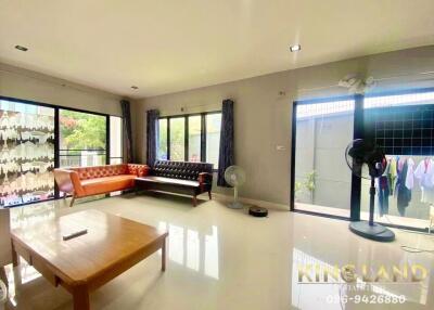 Spacious living room with sofas, coffee table, and large windows.