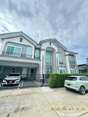 Exterior view of a large modern house with two cars parked in the driveway