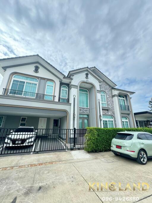 Exterior view of a large modern house with two cars parked in the driveway