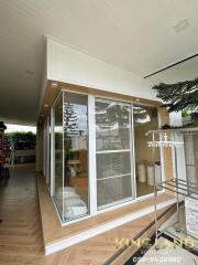 Modern sunroom with glass walls and wooden floor