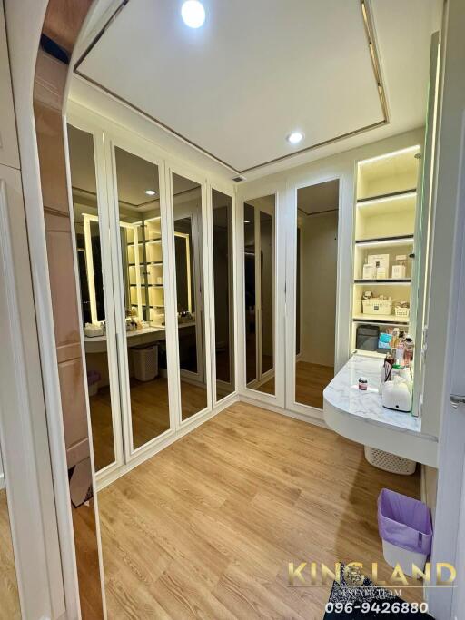 Spacious bedroom with mirrored wardrobes and wooden flooring