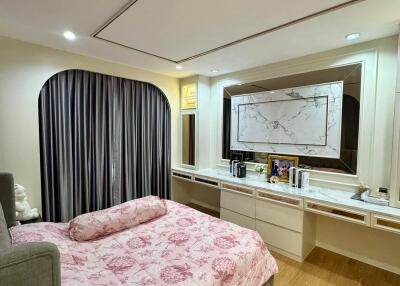 Bedroom with a floral bedspread, large mirror, and modern decor