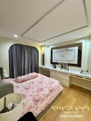 Bedroom with a floral bedspread, large mirror, and modern decor