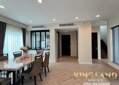 Modern dining area in an open-concept living space with a table, chairs, and large windows