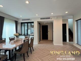 Modern dining area in an open-concept living space with a table, chairs, and large windows