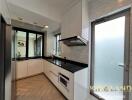 Modern kitchen with white cabinets and black countertop