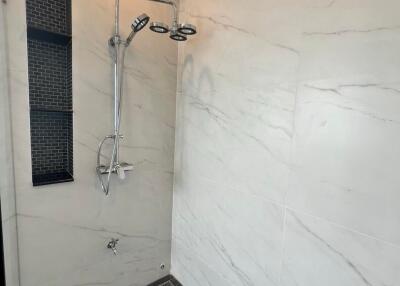 Modern bathroom with marble walls and rain shower system