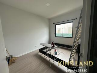 Minimalist bedroom with ironing board and window