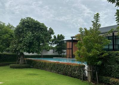 Outdoor area with a pool and manicured lawn